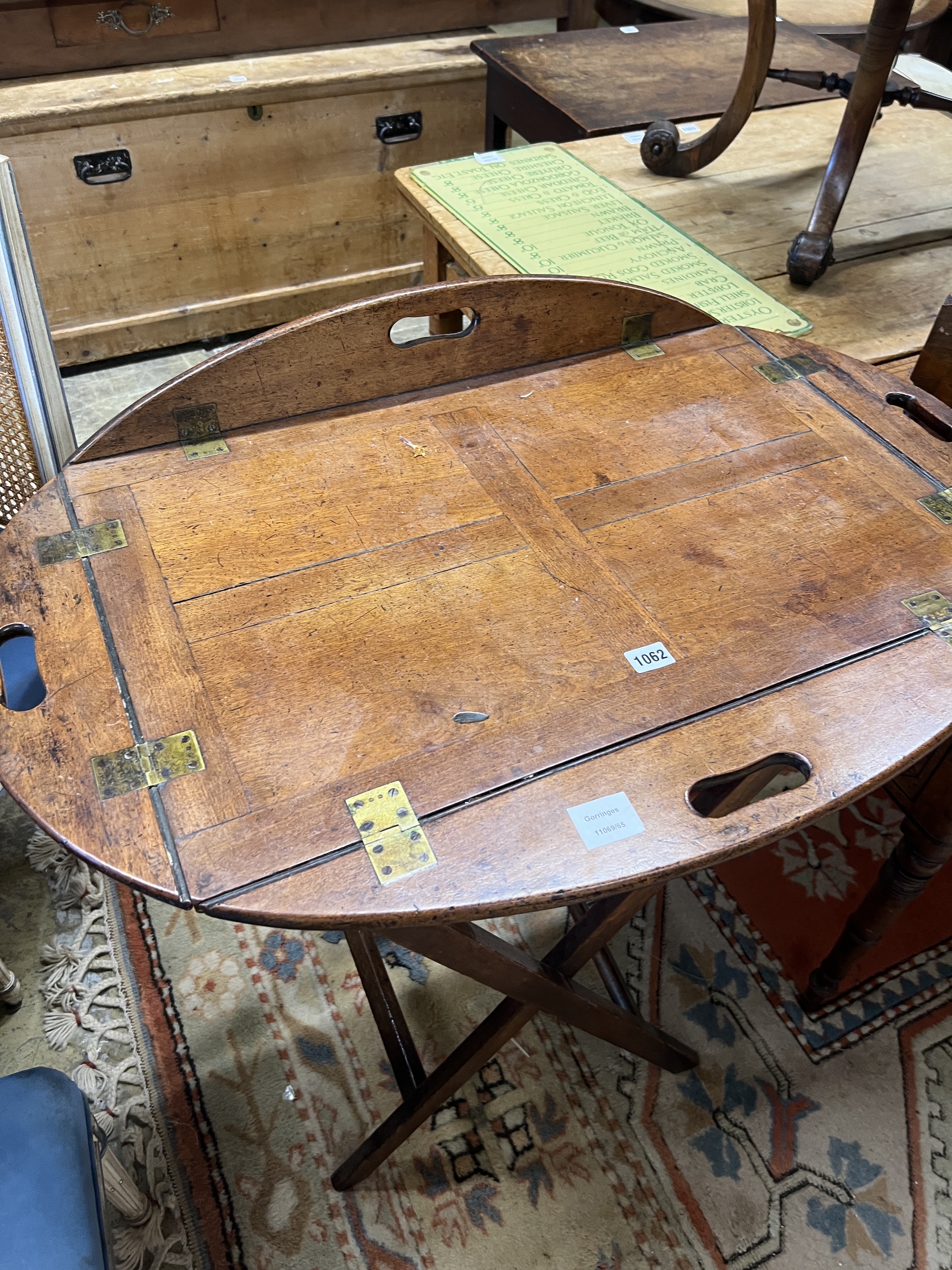 A Victorian brass mounted oval mahogany folding butler's tray / table on stand, width 90cm, height 82cm